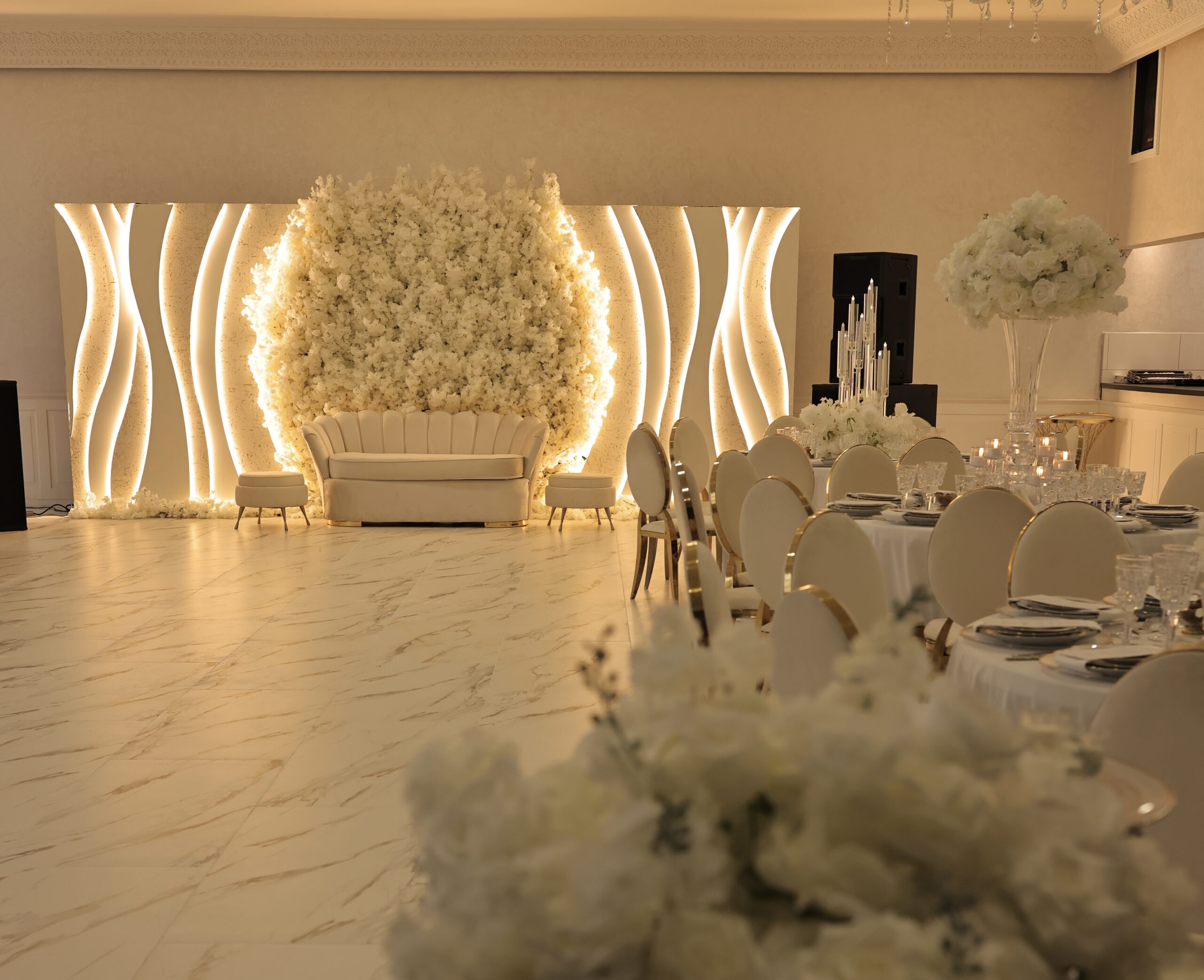 Bruiloftszaal met witte decoratie en bloemen